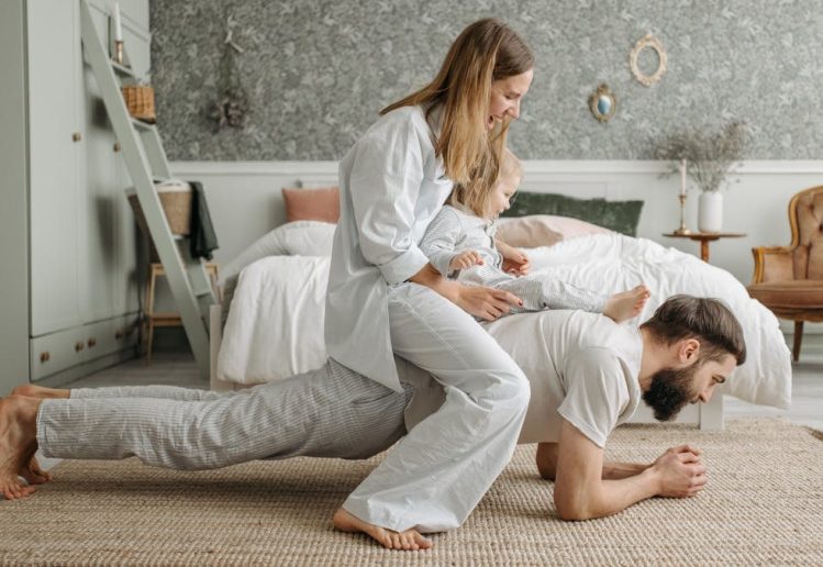 A joyful family enjoys playful bonding in a cozy bedroom, enhancing love and togetherness.