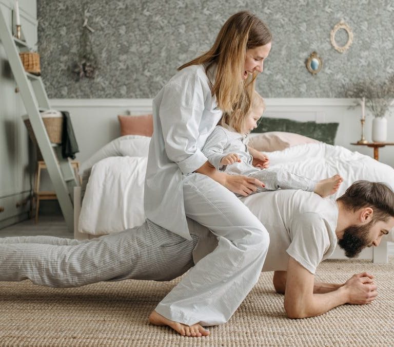 A joyful family enjoys playful bonding in a cozy bedroom, enhancing love and togetherness.